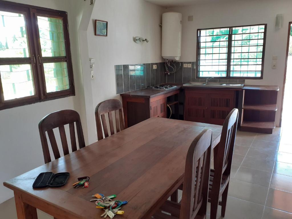 a kitchen with a wooden table and chairs at Villa Armor in Nosy Be