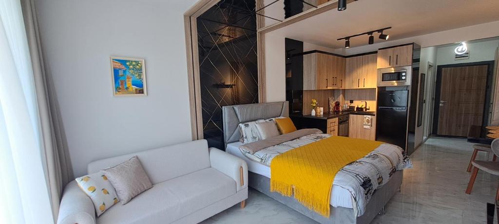 a bedroom with a bed and a couch and a kitchen at Infinity Studio, Shkorpilovtsi in Shkorpilovtsi