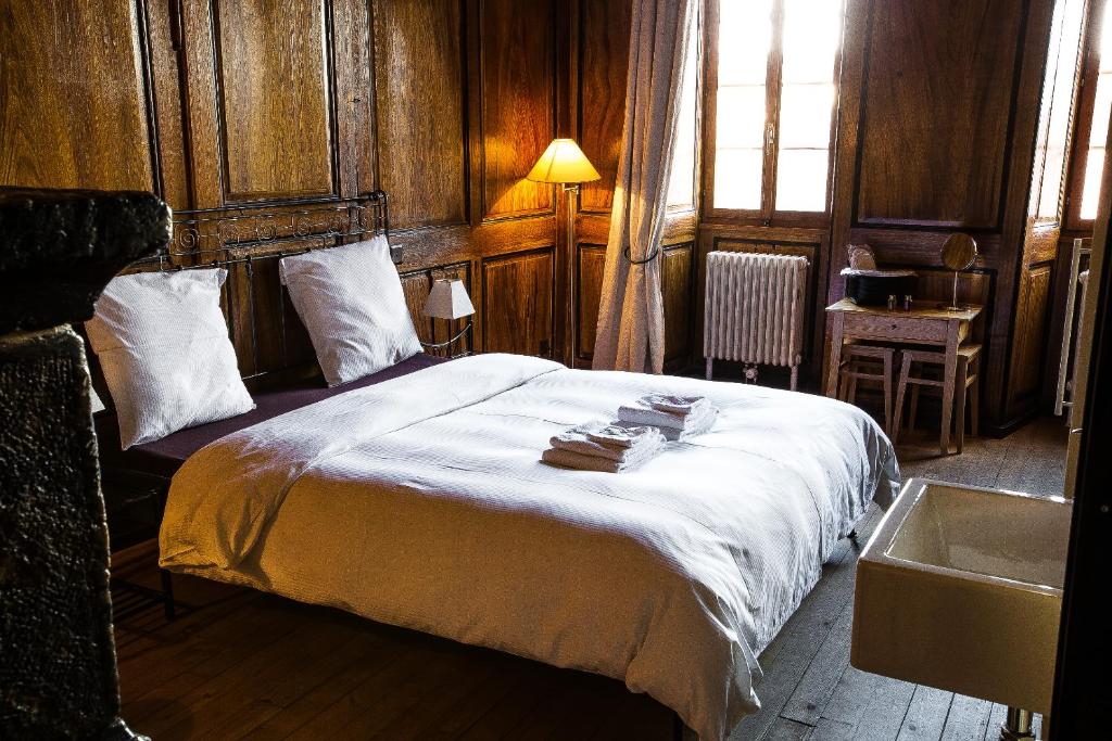 a bedroom with a large bed and a sink at La Grande Maison in Savièse