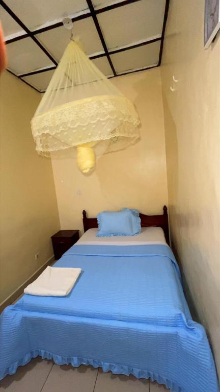 a bedroom with a blue bed with a chandelier at piece motel in Kigali