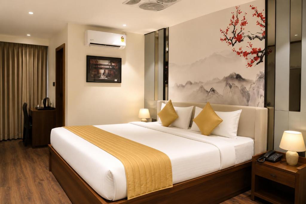 a bedroom with a large white bed with yellow pillows at Hotel Elite Executive Lodging in Bārāmati