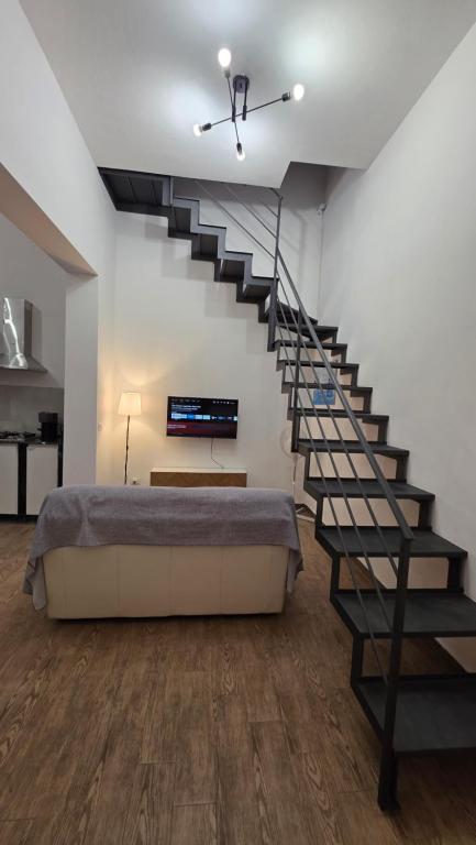 a bedroom with a bed and a spiral staircase at Mari del sud in Bagheria