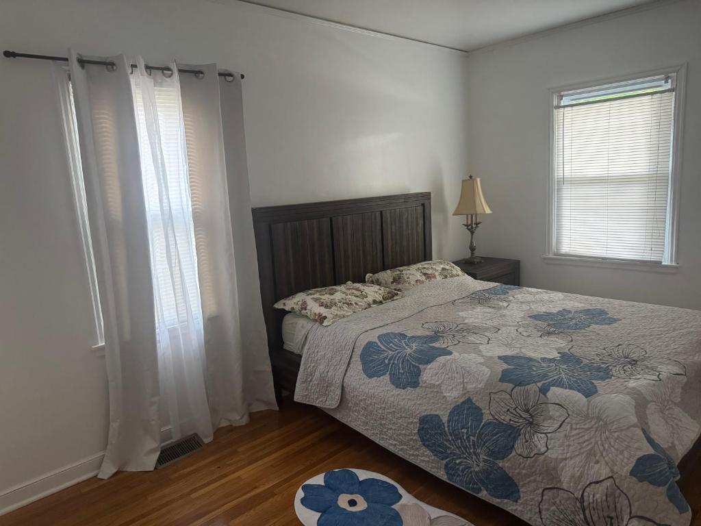 a bedroom with a bed and two windows and a rug at Logans Lodge in Minneapolis