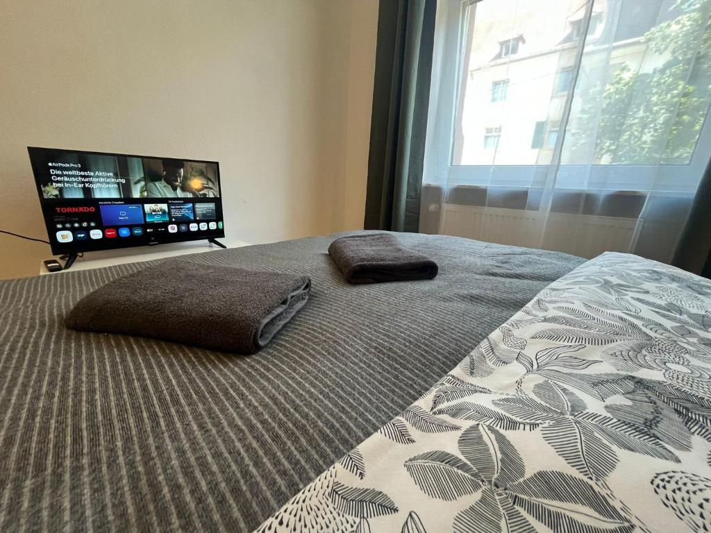 a bedroom with a bed with two pillows and a television at Süße Marie 19 - Coffee for free - in Karlsruhe