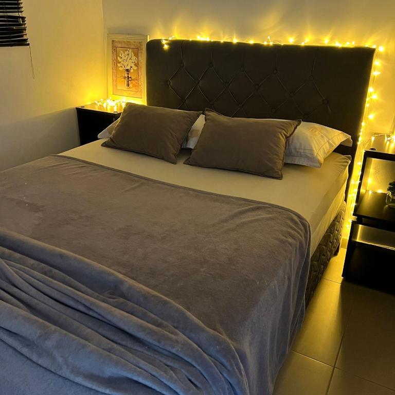 a bedroom with a large bed with lights on it at Apartamento Completo No Centro de Taboão da Serra in Taboão da Serra