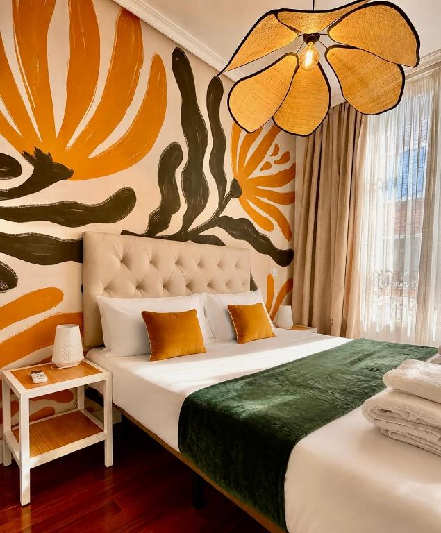 a bedroom with a bed with a painting on the wall at Callao Suites in Madrid