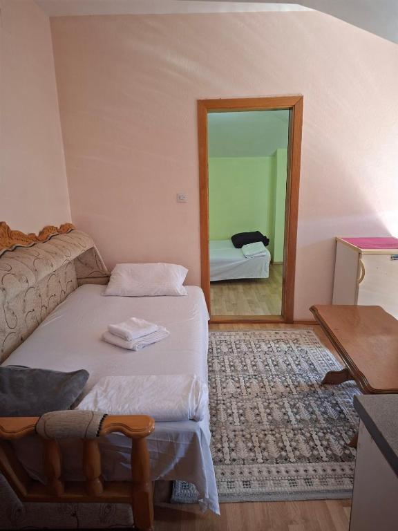 a room with two beds and a mirror at Apartmani Lazić No 11 in Gracanica
