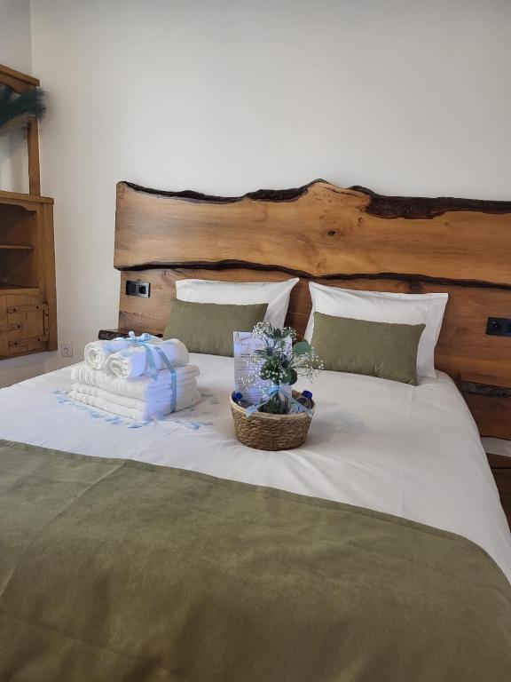 a bed with towels and a basket of flowers on it at Moinho da Quinta da Esperança in Ourém