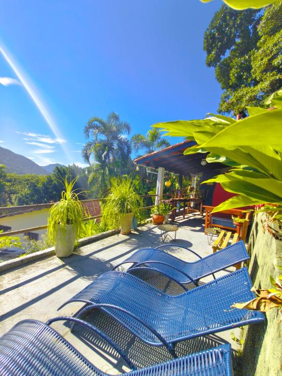 a group of blue chairs sitting on a deck at Quinta essência suites e chalés in Ubatuba