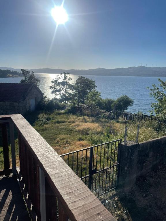a deck with a view of a lake with the sun at New Riyork Sweet Home in Geres