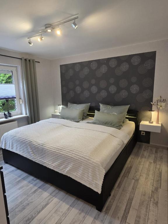 a bedroom with a large bed with a large headboard at WoDa's Hütte in Wickerode
