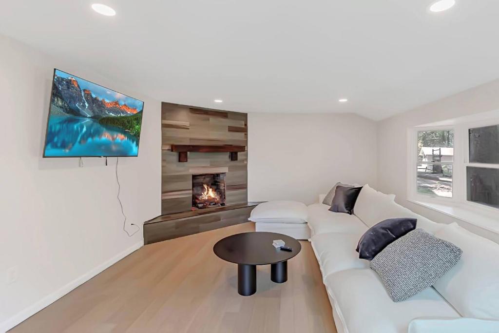 a living room with a white couch and a fireplace at Modern 3BR With Big Kitchen & TV Rm in State College