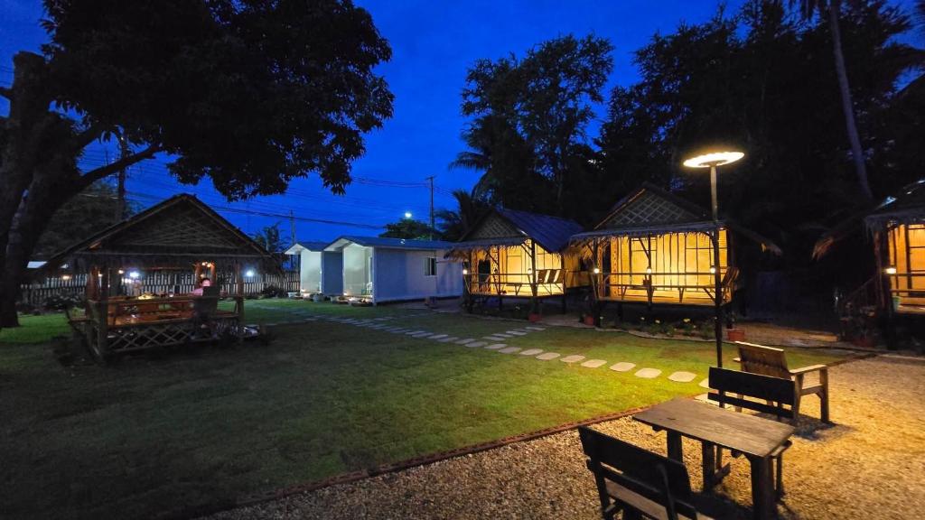 a group of cottages at night with a bench at Bamboo Khiri in Sathani Rot Fai