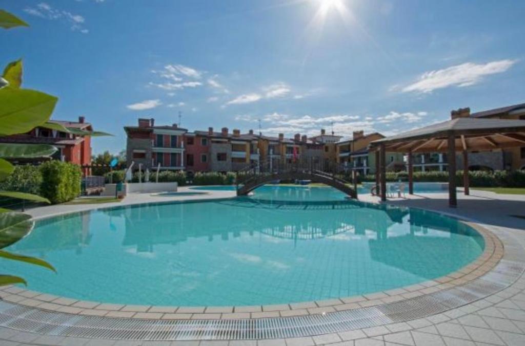 a large blue swimming pool with buildings in the background at Appartamento Corina in Sirmione