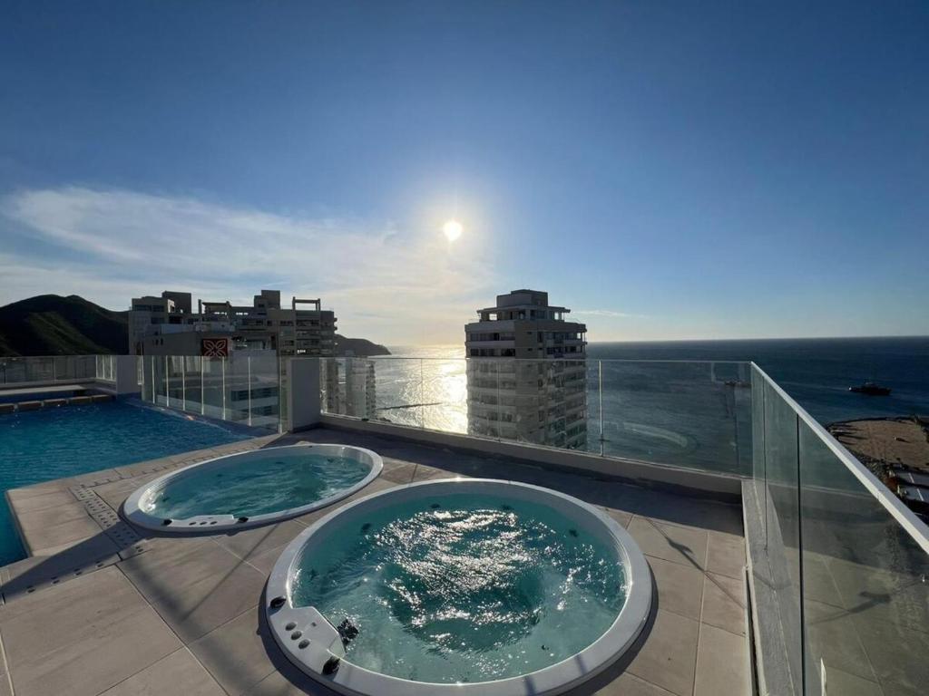 a hot tub on a balcony with a view of the ocean at Corredor Suite - Eira Building - Santa Marta in Santa Marta