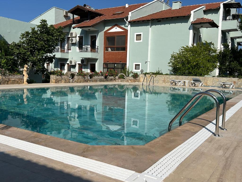a swimming pool with a stairway leading to a building at Ünlü Otel in Fethiye