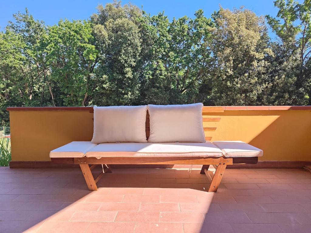a bench with two pillows sitting on a patio at Bolgheri 59 in Bolgheri