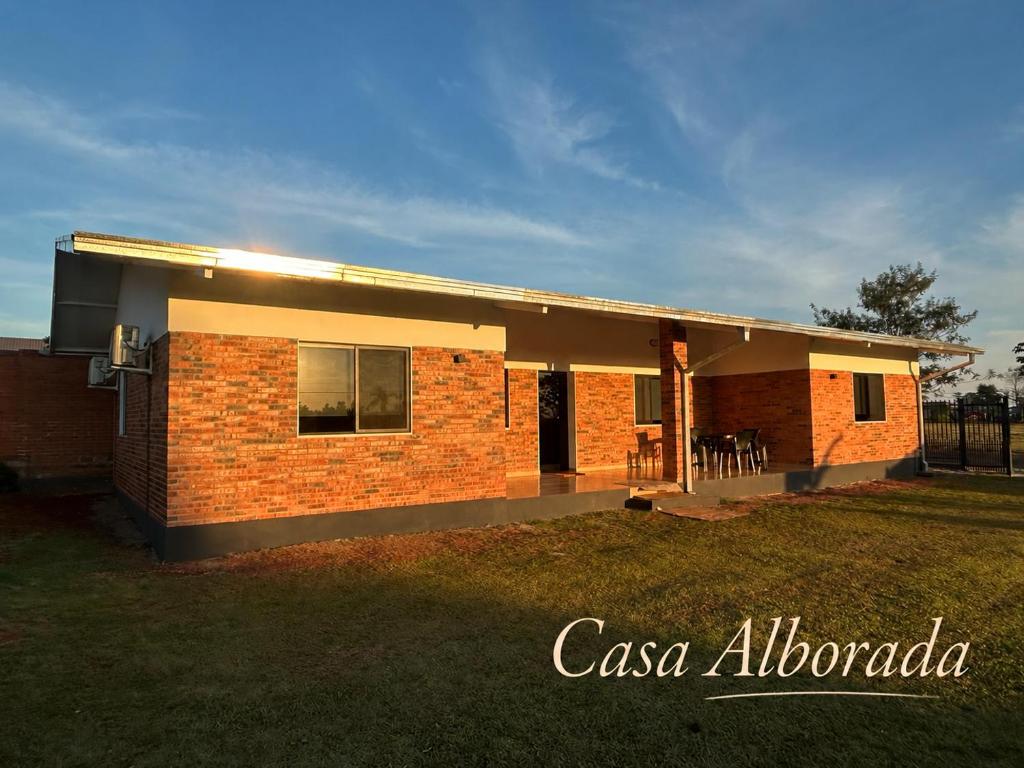 a brick house with a lawn in front of it at Casa Alborada Bella Vista Itapúa in Bella Vista