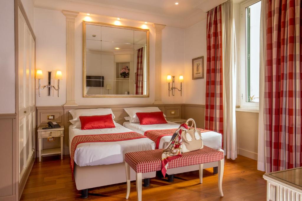 Pokój hotelowy z 2 łóżkami i lustrem w obiekcie Hotel Villa Glori w Rzymie
