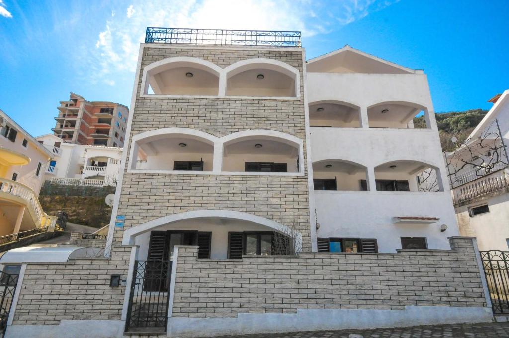 a tall white building with stairs in front of it at Bologna Apartments in Budva