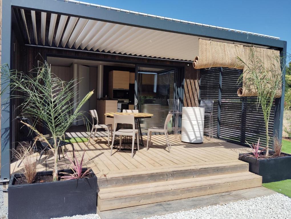 a wooden deck with a table and chairs on it at Cottage haut de gamme, tout confort in Agde
