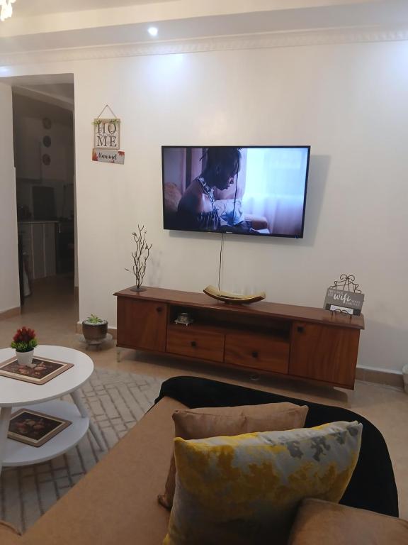 a living room with a flat screen tv on a wall at The Bird House in Munyu