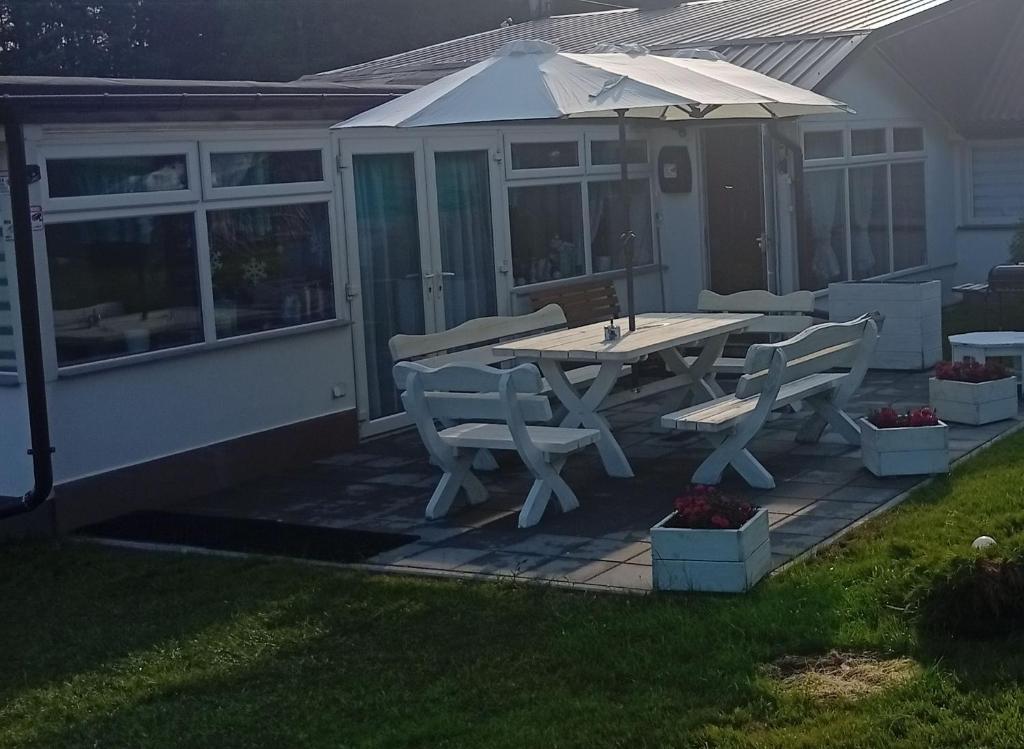 a patio with a table and chairs and an umbrella at Domek Agroturystyczny Doris in Stężyca