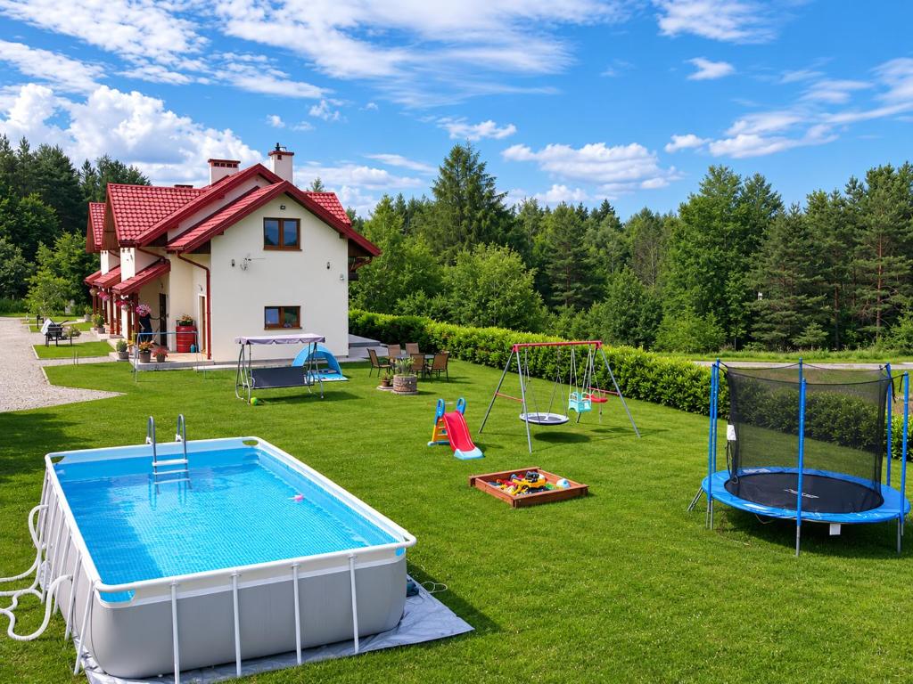 a backyard with a pool and playground equipment at Willa Panorama 881-751-206 in Polańczyk