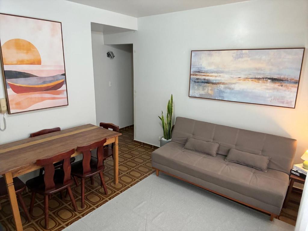 a living room with a couch and a table at Apartamento Brisa Do Mar em Peruíbe in Peruíbe