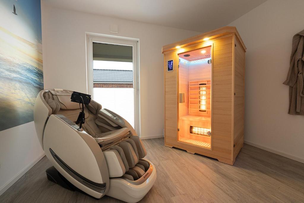 a room with an empty chair in front of a door at Sonne & Sand Strandnahes Ferienhaus mit Whirlpool, Sauna & Wallbox in Büsum