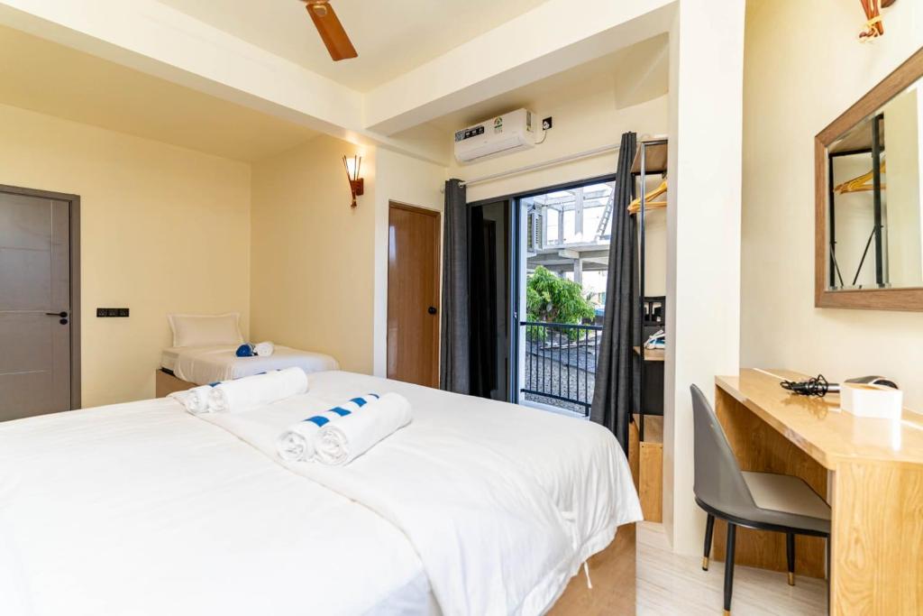 a bedroom with a bed and a desk and a window at White Sand Maldives in Ukulhas