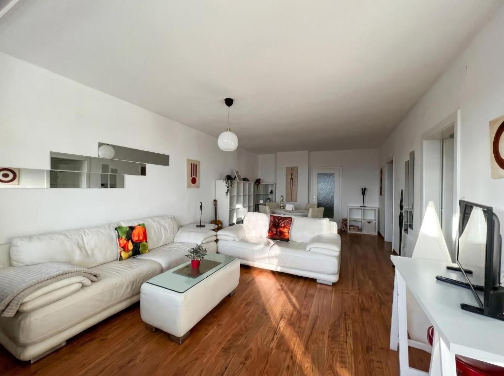 a living room with two white couches and a table at Fernblick Appartement Simonhöhe in Zirkitz