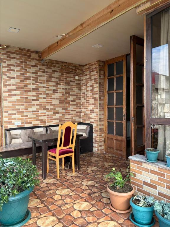 a patio with a wooden table and a chair at Qobuleti, Rustaveli street 162 e in Itʼkhvisi