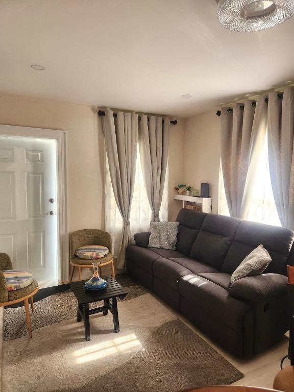 a living room with a couch and a table at Jadens Guest House - by ZenBreak in Saint Michael