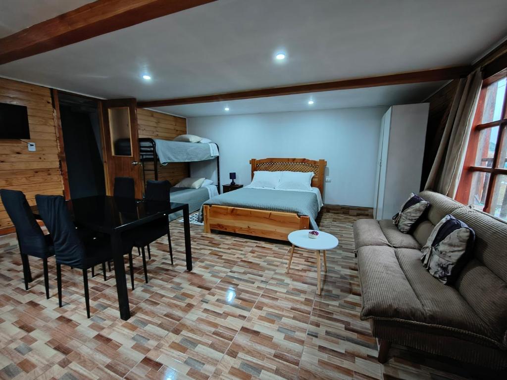 a living room with a bed and a couch at Cabañas CyG 2 - Chaitén in Chaitén