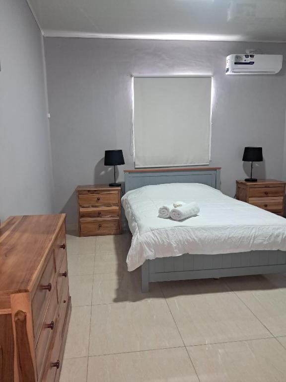 a bedroom with a bed and two dressers and a window at Hotel Inter in Penonomé