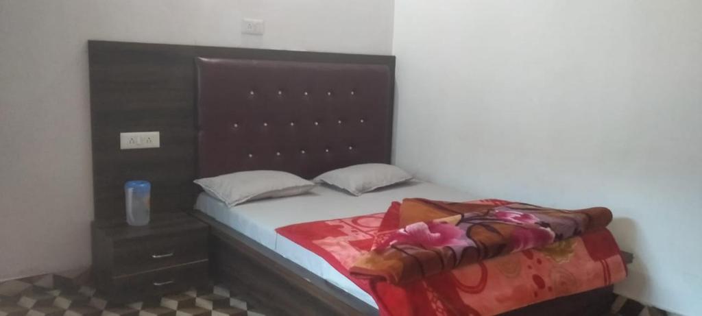 a bedroom with a bed with a wooden headboard at Bahram vatika in Sonprayag