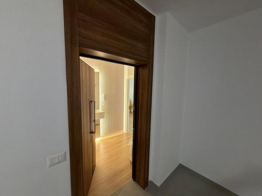 a wooden door leading into a room with a hallway at Apartment 51 Luxury in Kamëz