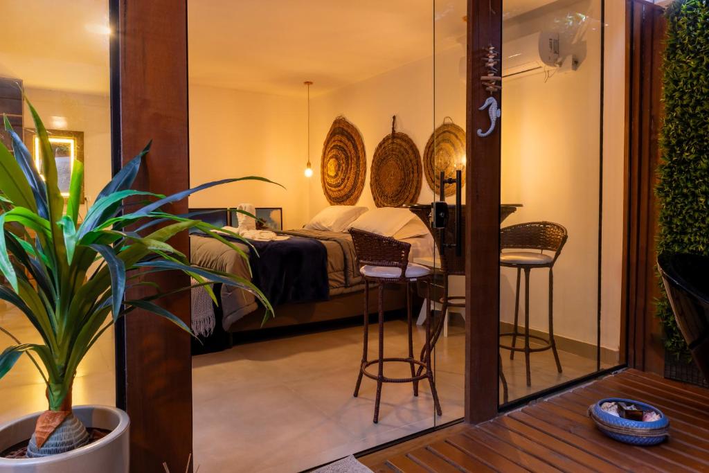 a bedroom with a bed and a table and chairs at Pousada e Chalé Lote 22 in Ilha do Mel