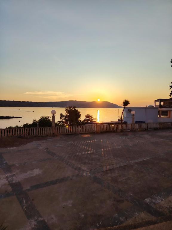 a sunset over the water in a parking lot at Studio apartman Pepi in Stinica
