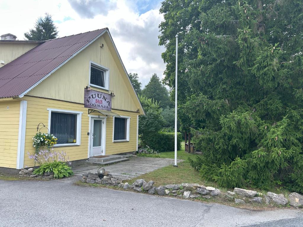 a yellow building with a sign on the side of it at Puuna Öömaja B&B in Vihterpalu