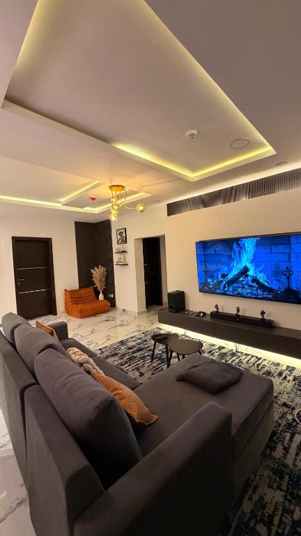 a living room with a large tv and a couch at The bliss spot in Lekki