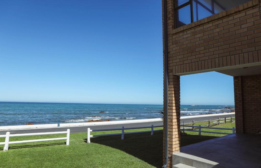 a brick building with a view of the ocean at Franskraal Zeehoek in Franskraalstrand