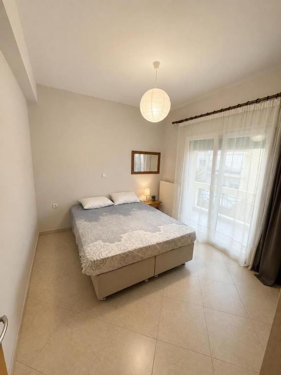 a bedroom with a bed and a large window at Seaside Escape in Nea Peramos