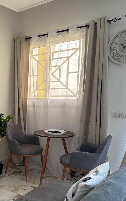 a living room with a table and chairs and a window at Le bungalow by mk in Nzogobeyork