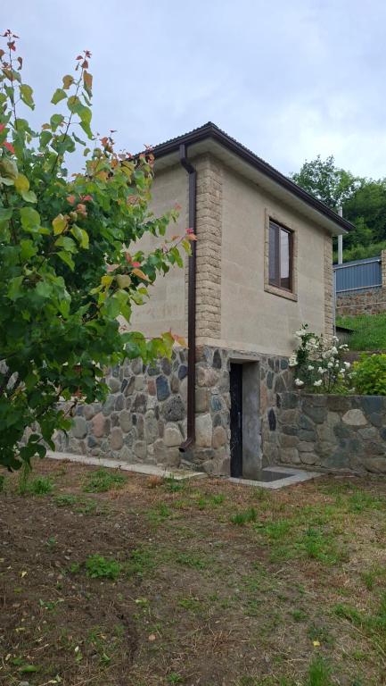 a stone house with a stone wall at Shen toon cottage in Shnogh