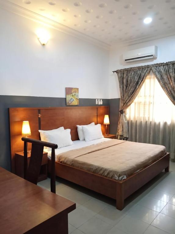 ein Schlafzimmer mit einem großen Bett und einem Fenster in der Unterkunft Embel Hotel in Port Harcourt