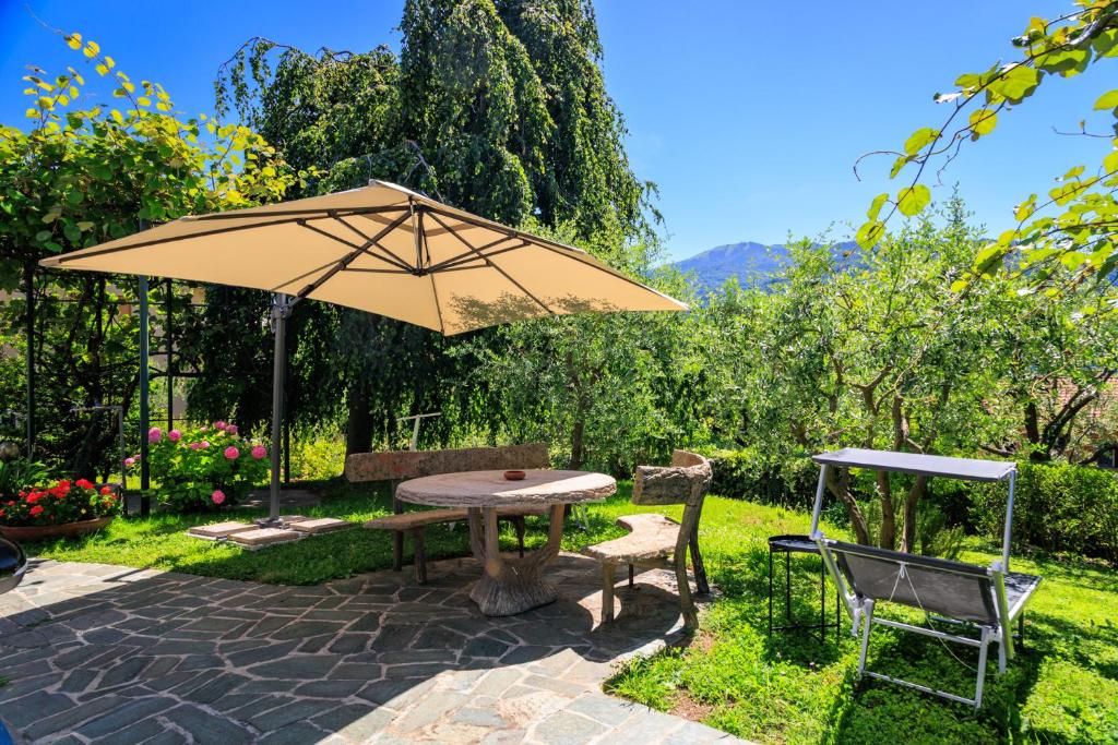 a patio with an umbrella and a table and chairs at Casa Flavia in Lierna