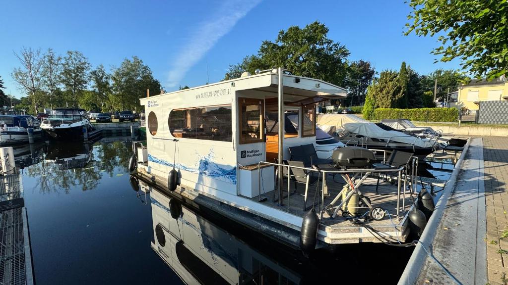 a small boat is docked in the water at Hausboot in Berlin, festliegend im Yachthafen Schmöckwitz, mit Heizung in Berlin