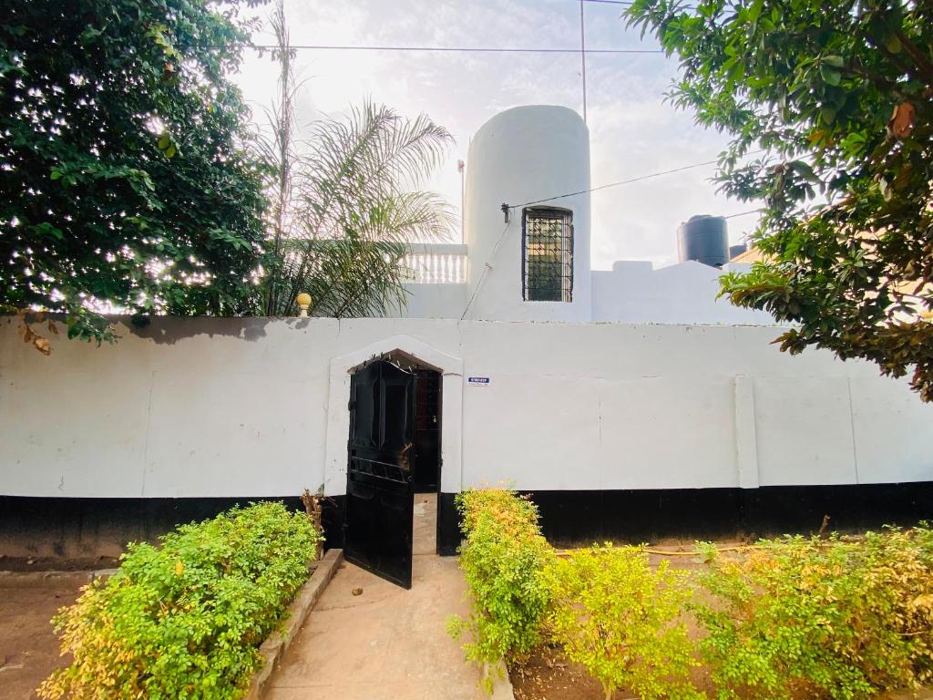a white building with a door and a window at Home & Heart Gambia in Brusubi